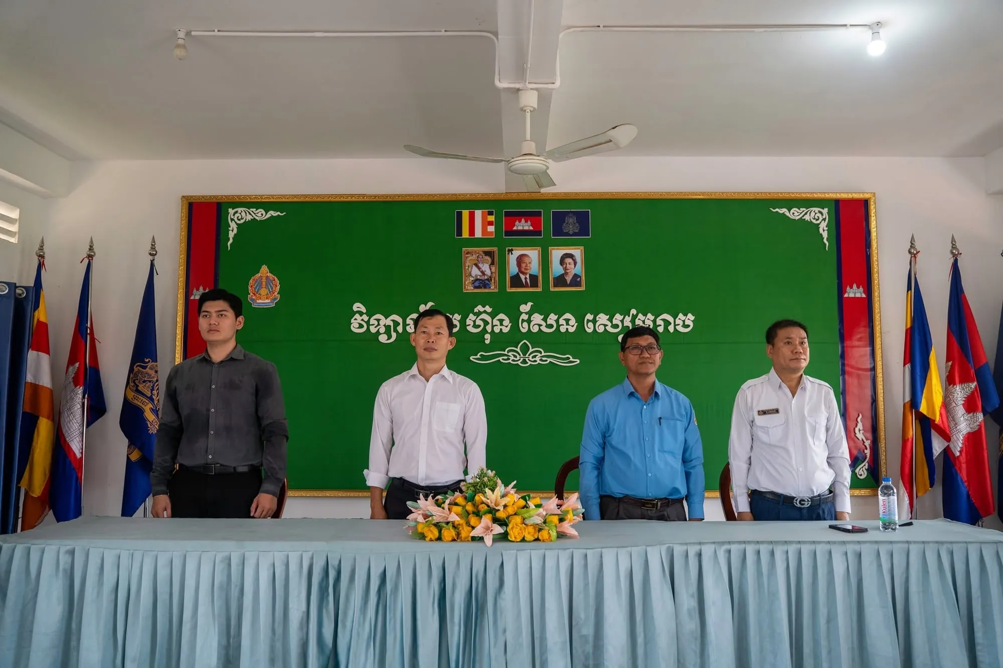 Organisers standing at the front table under the school banner