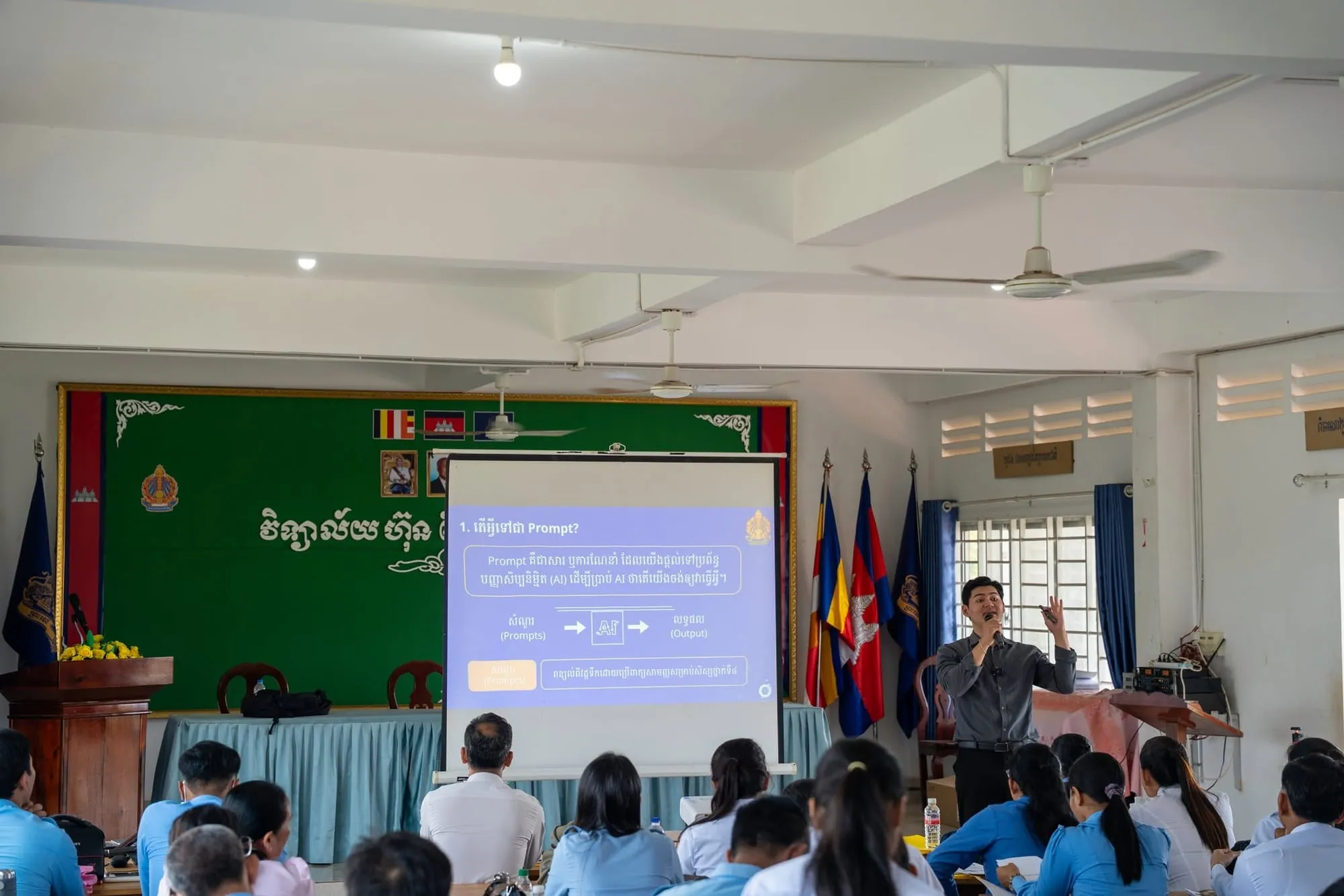 Wide view of the hall: the presenter at the front and seated participants